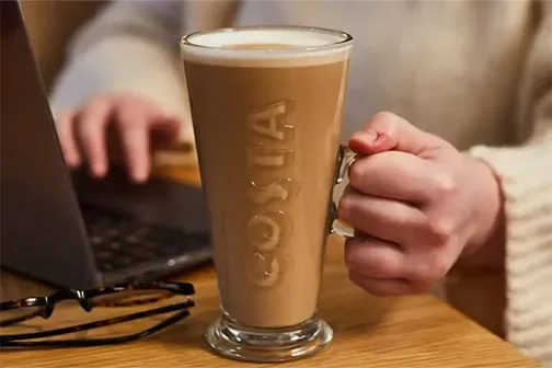 Woman with our Maple Hazel range coffee at Costa Coffee.
